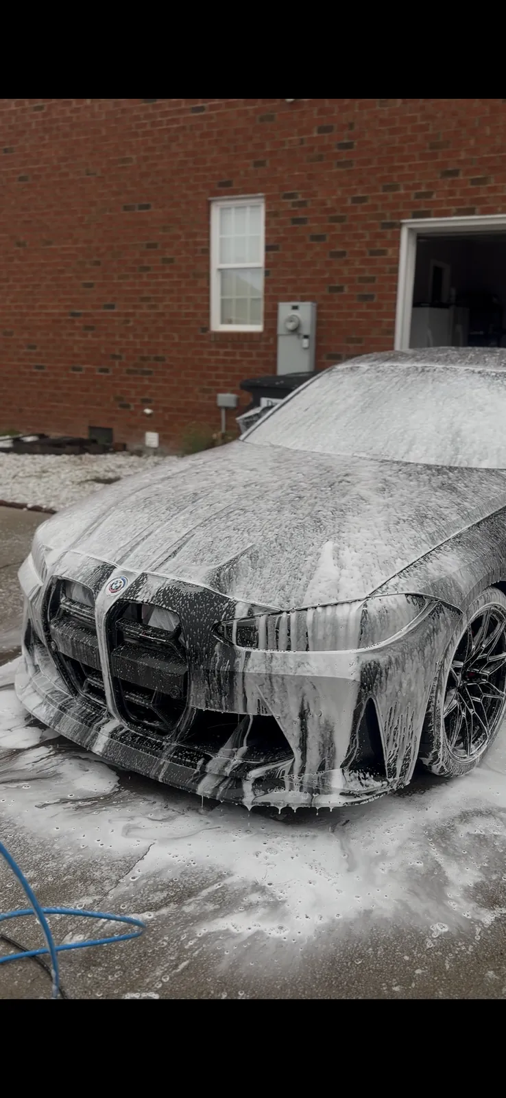 A BMW being covered in foam during an exterior detail