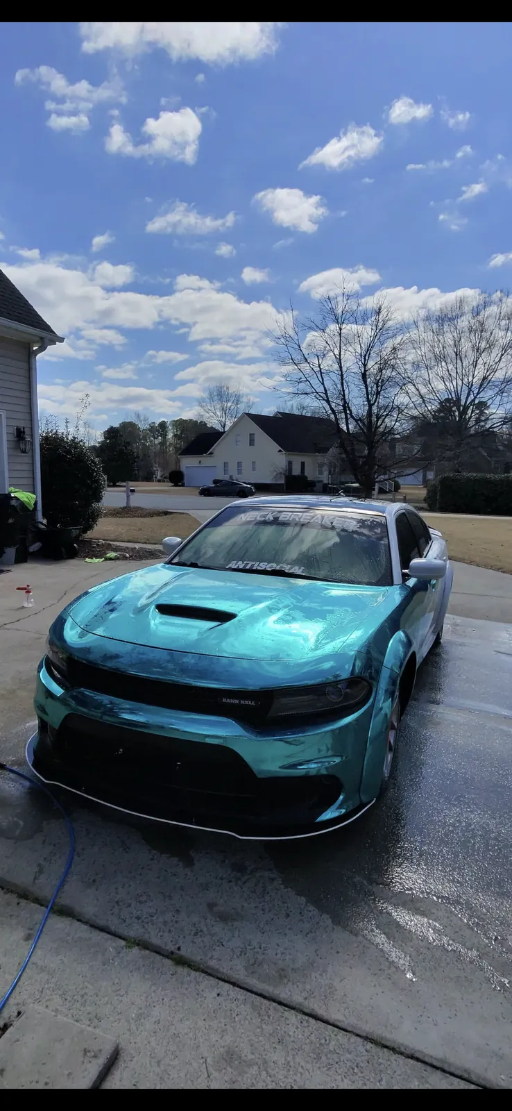 Teal Dodge Charger after a mobile exterior wash in a residential driveway